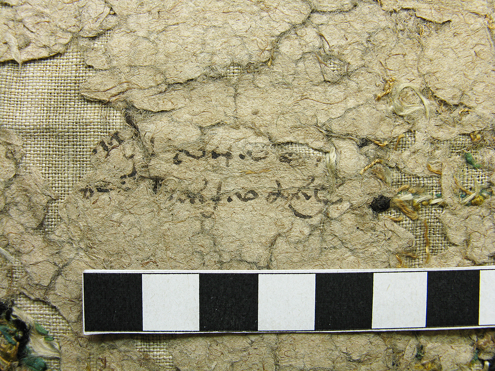 Detail of paper backing, with early writing on the reverse.