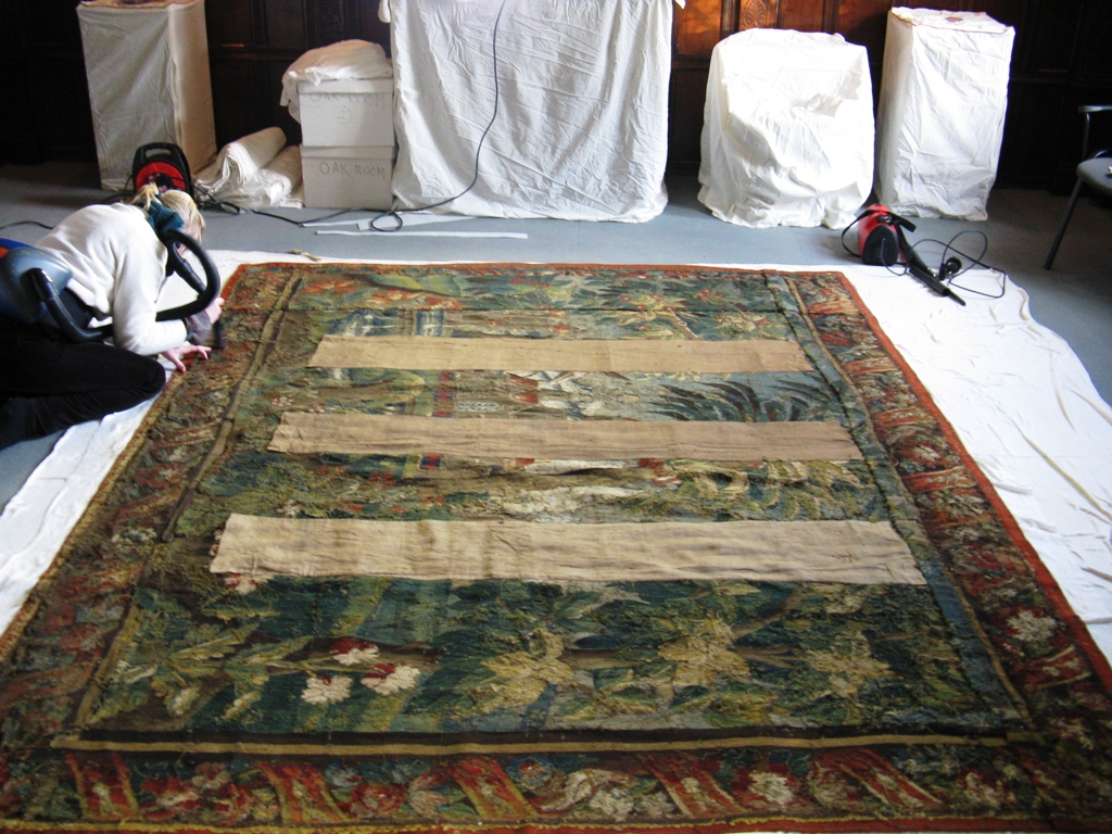 Surface cleaning a tapestry on site.