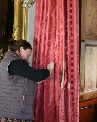 The curtain shown above, now loose, with conservator hard at work on it.