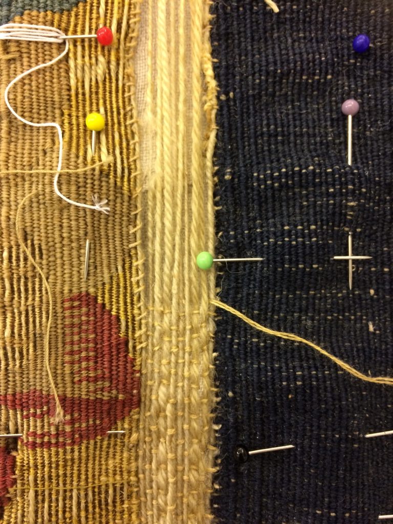 During conservation, inserting new warps along the lower edge and stitching them down