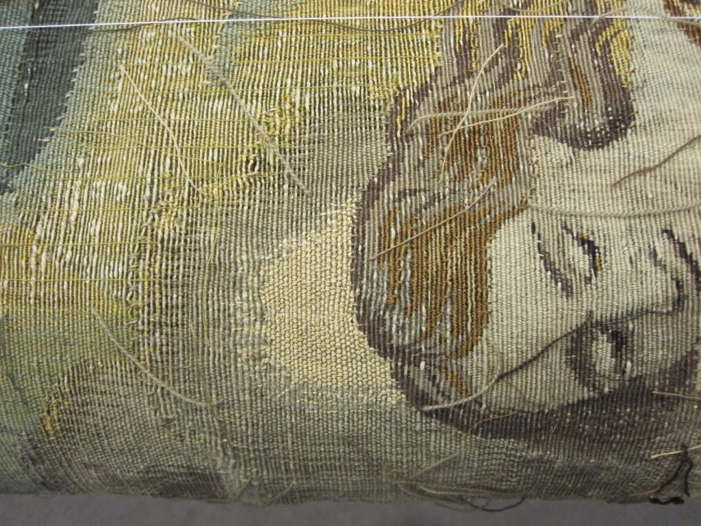 A previous woven repair was left in place above the figure's head, and the area around it strengthened
